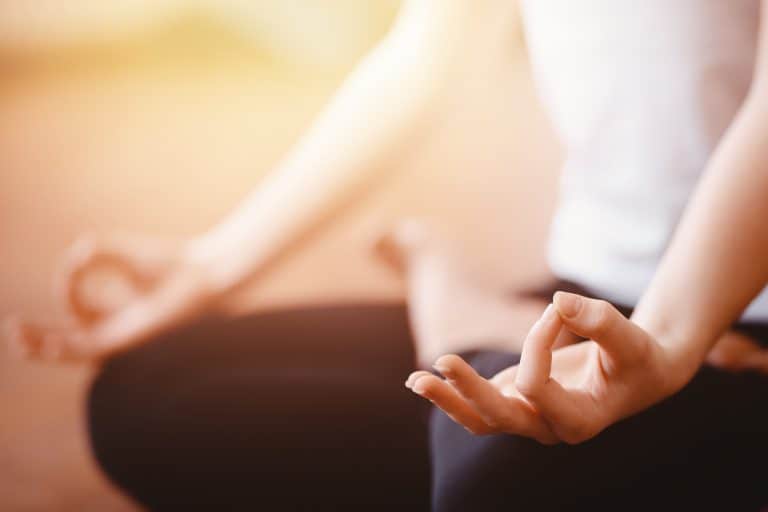 Detailaufnahme Frau auf Yogamatte meditierend